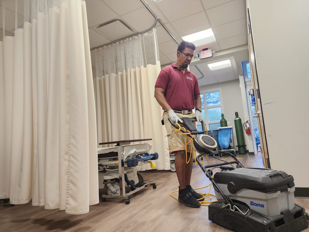 Dust Buster Services employee scrubbing floors in a government medical facility