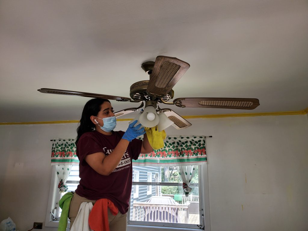 Dust Buster’s employee cleaning a ceiling fan during residential deep cleaning