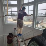 Dust Buster’s team member cleaning stairway window during residential deep cleaning in New Jersey