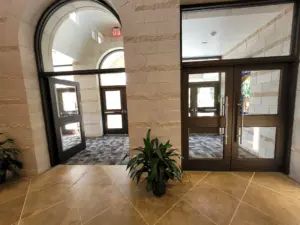 Tile entryway with carpeted vestibule and glass doors